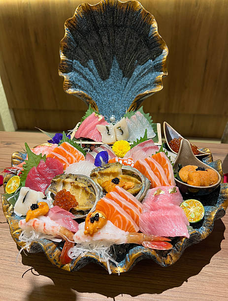 An assorted sashimi platter with a selection of fish, fresh abalone, sea urchin, and sweet shrimp