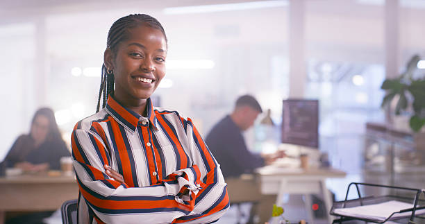 istock Confident Professional Woman Posing in Modern Office Environment with Colleagues in Background 2218728018
