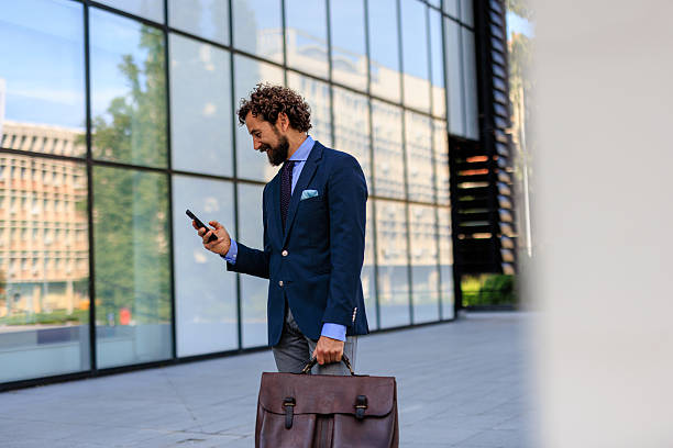istock Corporate Professional with Briefcase Looking at Phone Outdoors 2218732416