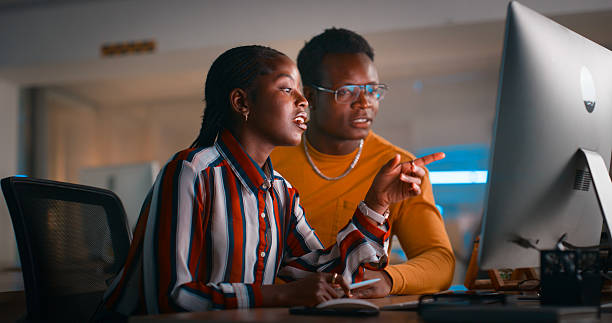 istock Two Professionals Collaborating on a Computer in a Modern Indoor Office Environment 2218732493
