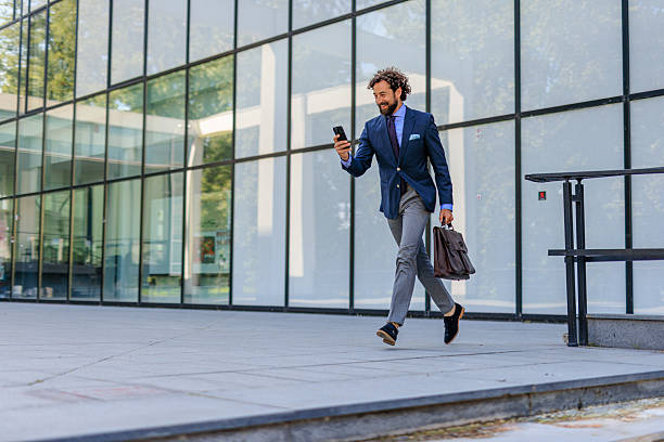 istock Confident Executive Heading to Next Meeting with Briefcase and Phone 2218732708