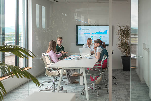 istock Professional Business Executives Collaborating in Modern Glass-Walled Boardroom with Digital Presentation 2218733010