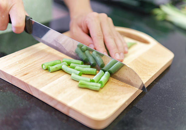 istock Woman hands cutting fresh green beans in a kitchen 2218736407