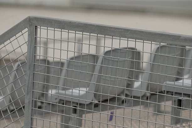 This image captures a closeup of empty stadium seats enclosed by a sturdy wire fence, highlighting the unique structure and meticulous arrangement of seating in a sporting venue