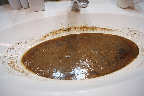 istock Dirty water clogging a bathroom sink due to a blocked drain 2218739935