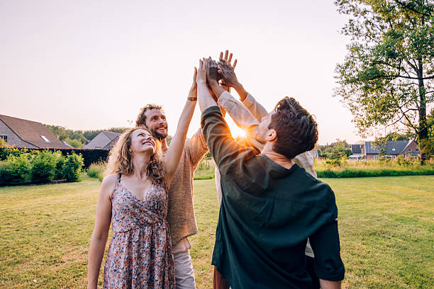 istock Young adults joining hands together in a backyard celebration 2218741298