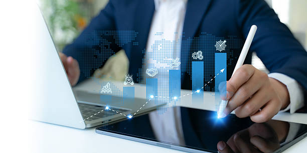 istock Business growth strategy concept. A professional uses a digital tablet to interact with blue bar graphs and business strategies icons; teamwork, innovation, business collaboration, sustainability. 2218745821