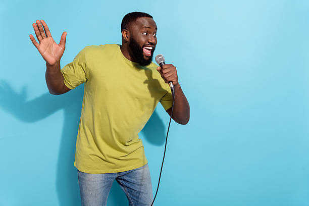 istock Photo of attractive guy dressed green t-shirt singing microphone empty space isolated blue color background 2218746796