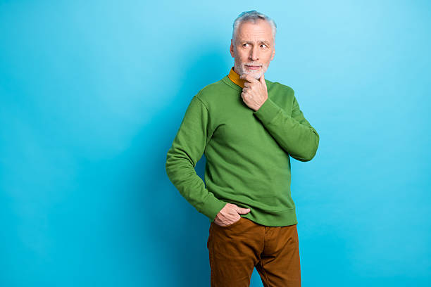 istock Photo of thoughtful man pensioner dressed green pullover arm chin looking empty space isolated blue color background 2218746814