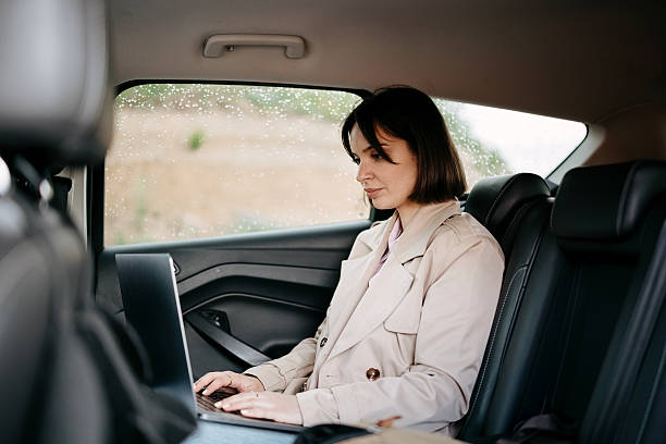 istock Woman using a laptop in a car 2218751186