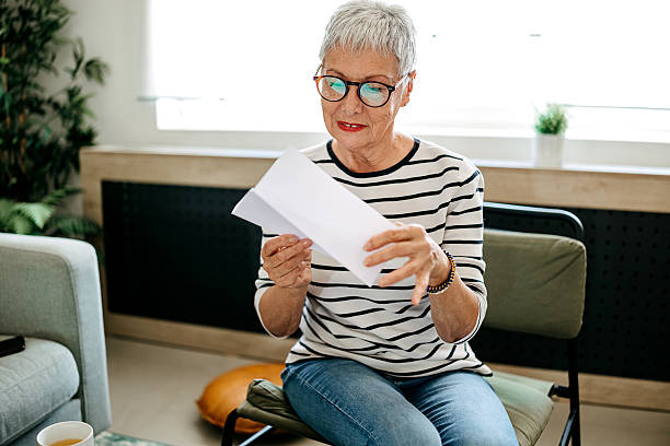 istock Senior woman at home checking her mail 2218751298