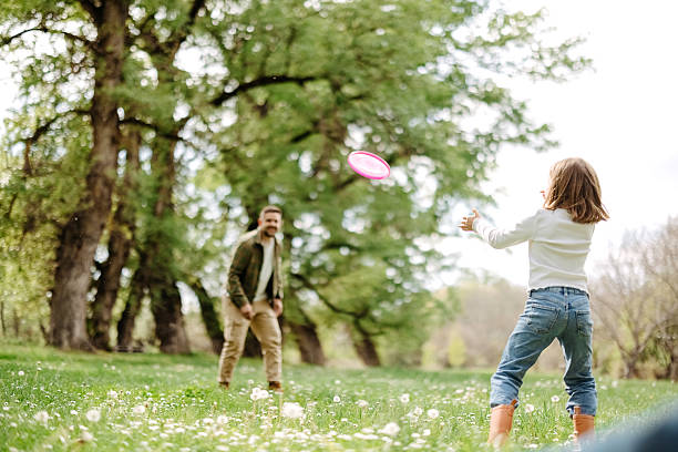 istock Girl plays frisbee with her father 2218751876