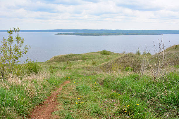 istock Scenic view of a river, hills and grassy terrain under a cloudy sky 2218753325