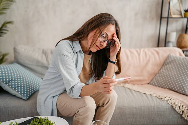 istock Disappointed Young Woman Taking A Pregnancy Test At Home At Night 2218755521