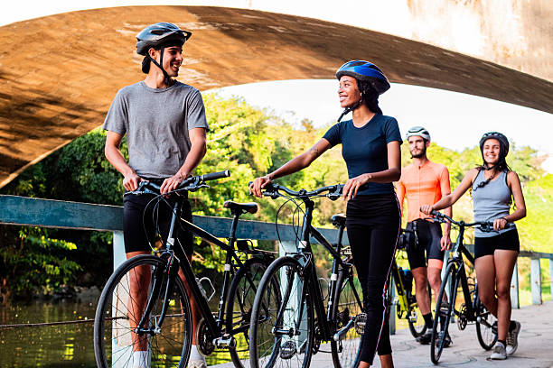 Young cyclists talking and walking outdoors