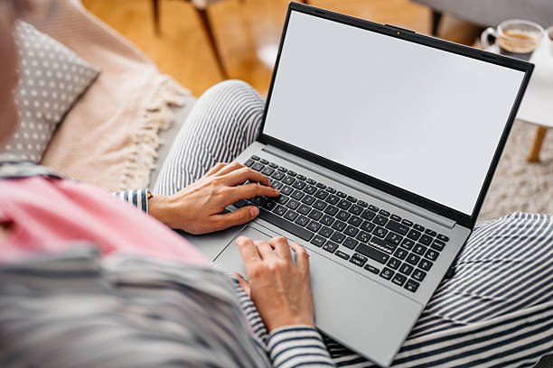 istock Young Woman Working On A Laptop While Sitting On The Sofa At Home 2218756853
