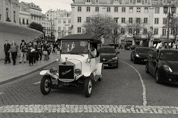 Lisbon, Portugal - Mars 16, 2024: A tuk-tuk rides with tourists on a street in Lisbon downtown.