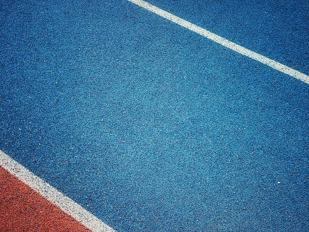 istock orange and blue Running track with white stripes  in top view. 2218757503