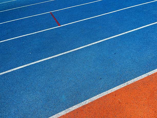 istock orange and blue Running track with white stripes  in top view. 2218757504
