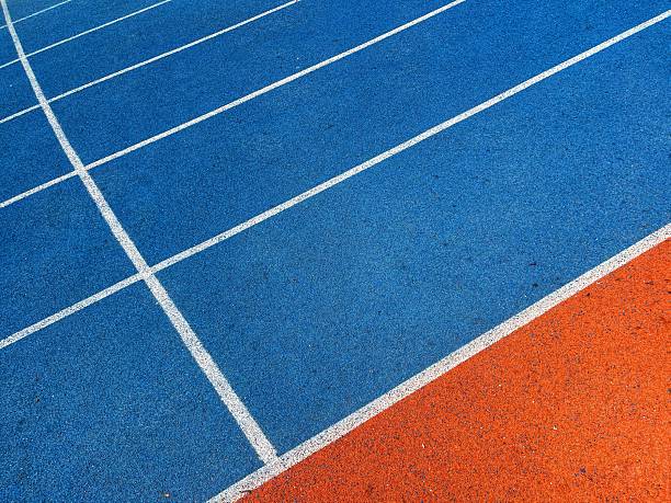 istock orange and blue Running track with white stripes  in top view. 2218757506
