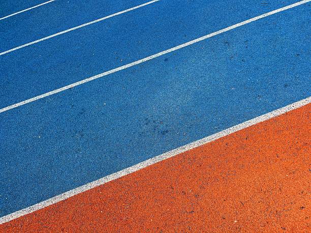 istock orange and blue Running track with white stripes  in top view. 2218757515