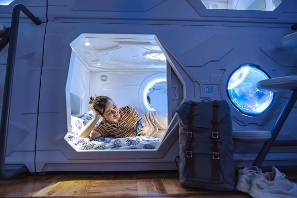 istock Person resting in a futuristic capsule room and using smartphone while enjoying a comfortable travel experience 2218757960