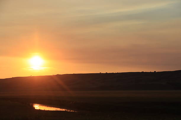 istock Sunset through the trees and over the hills. 2218760336
