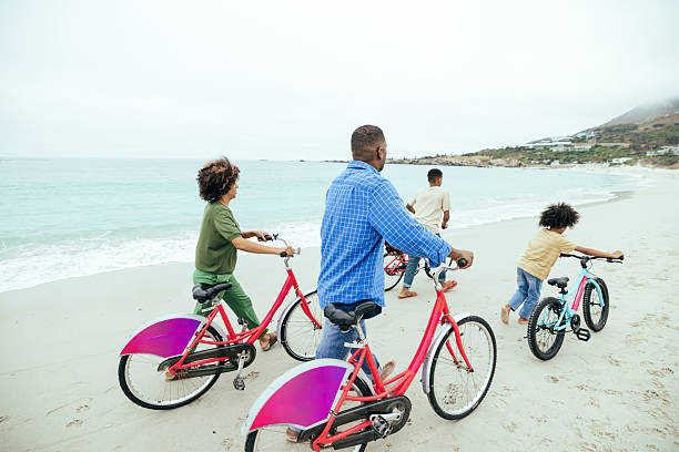 Cyclists ride along the seaside promenade with the Atlantic Ocean in view. Cadiz, Andalusia, Spain, September 2025. High quality photo