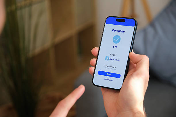 istock Man completing mobile payment on smartphone at home 2218761404