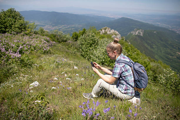 istock Solo Female Traveler Pausing to Check Phone on Trail 2218761484