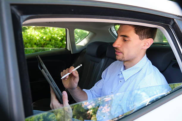 istock Businessman working on tablet with stylus in car 2218761585