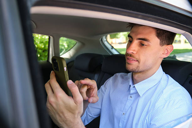 istock Businessman using smartphone in backseat of car 2218761761