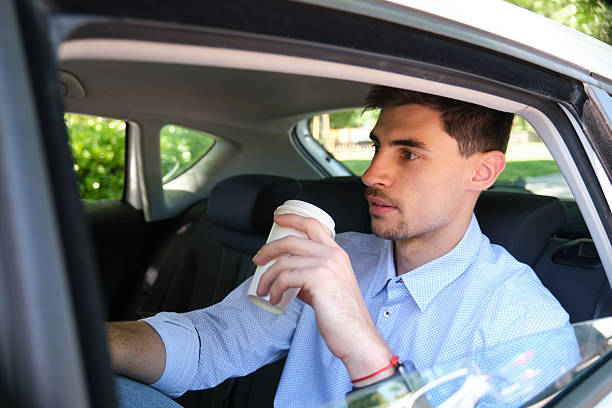 istock Young businessman drinking coffee in his car 2218761884