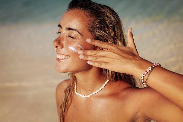 istock Smiling Woman Applying Sunscreen on Tropical Beach 2218762785