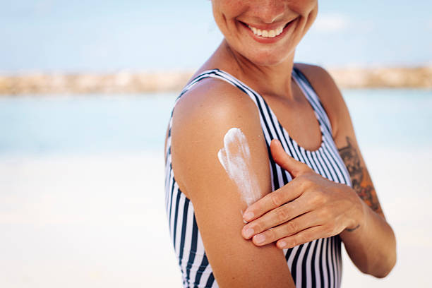 istock Smiling Woman Applying Sun Cream 2218763484