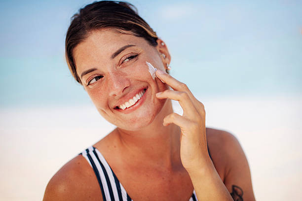 istock Woman Applying Sunscreen on Tropical Beach 2218763647