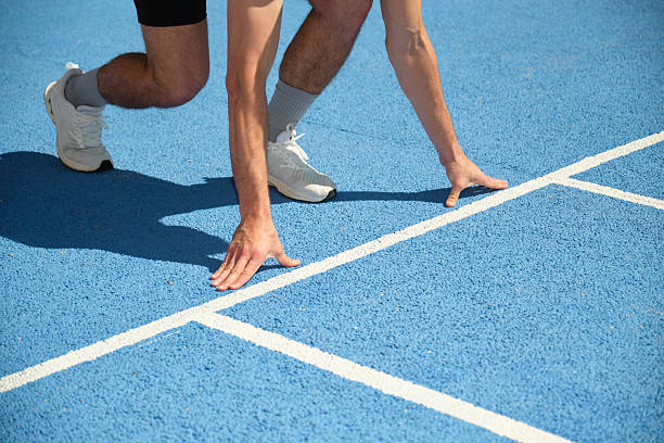 Runner preparing for a race on a blue track
