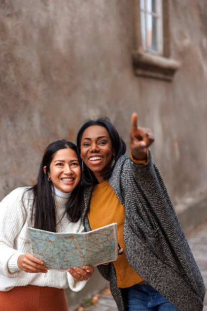 istock Friends on vacation using map while sightseeing in new city 2218765502