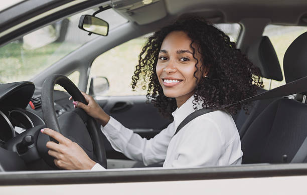 istock Smiling young woman driving a car 2218770611