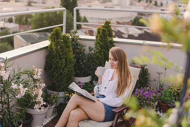 istock Woman with Coffee Reading Book on Rooftop Garden 2218771742