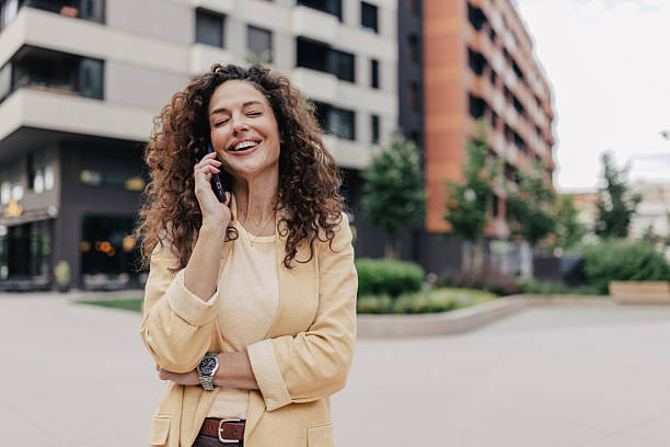 istock Cheerful woman talking on phone outdoors in urban 2218775464