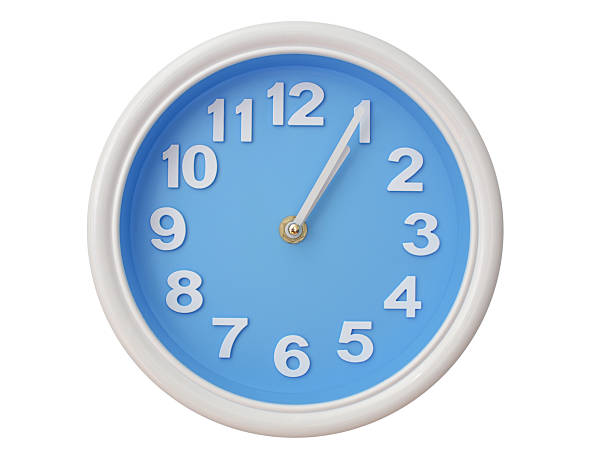 Wall clock with a blue face and white frame showing exactly 01:05 or 13:05. Represents time, deadlines.