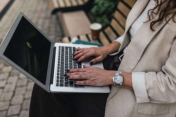 istock Stylish Woman Using Laptop on a Park Bench 2218776776