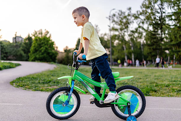 istock Boy enjoys cycling in a public park during springtime while smiling and having fun outdoors 2218777800
