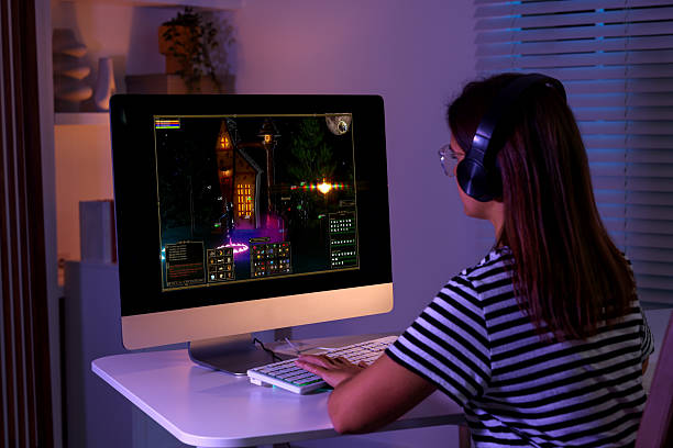 istock Woman playing video game with keyboard at table indoors, back view 2218779558