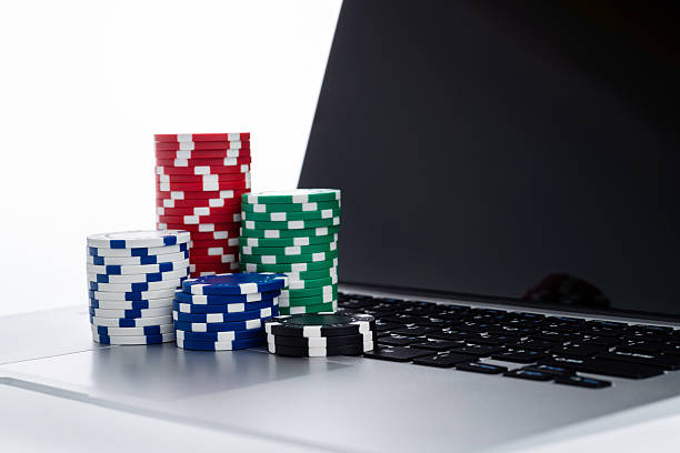 istock Laptop keyboard with gambling chips on white background 2218781011