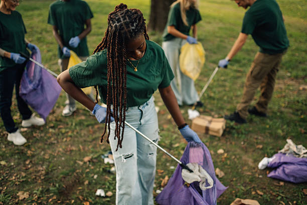 istock Volunteers picking up trash in park using trash picker and bags 2218781119