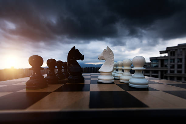 Two chess knights battle on city background.