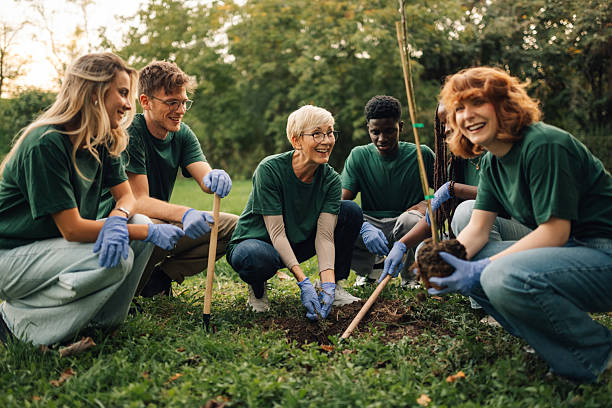 istock Volunteers planting trees in a park working together 2218781308