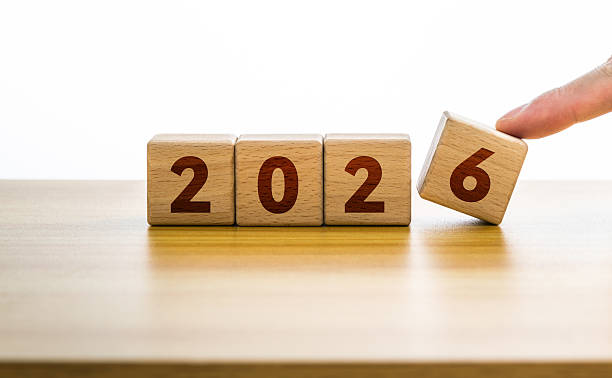 istock Man finger putting wood cube 2026. New year 2026 concept 2218781365